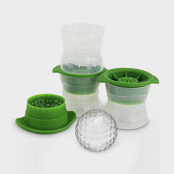 Green silicone molds encase clear ice ball makers, shown disassembled on a plain white background. A transparent, dimpled ice sphere rests nearby.