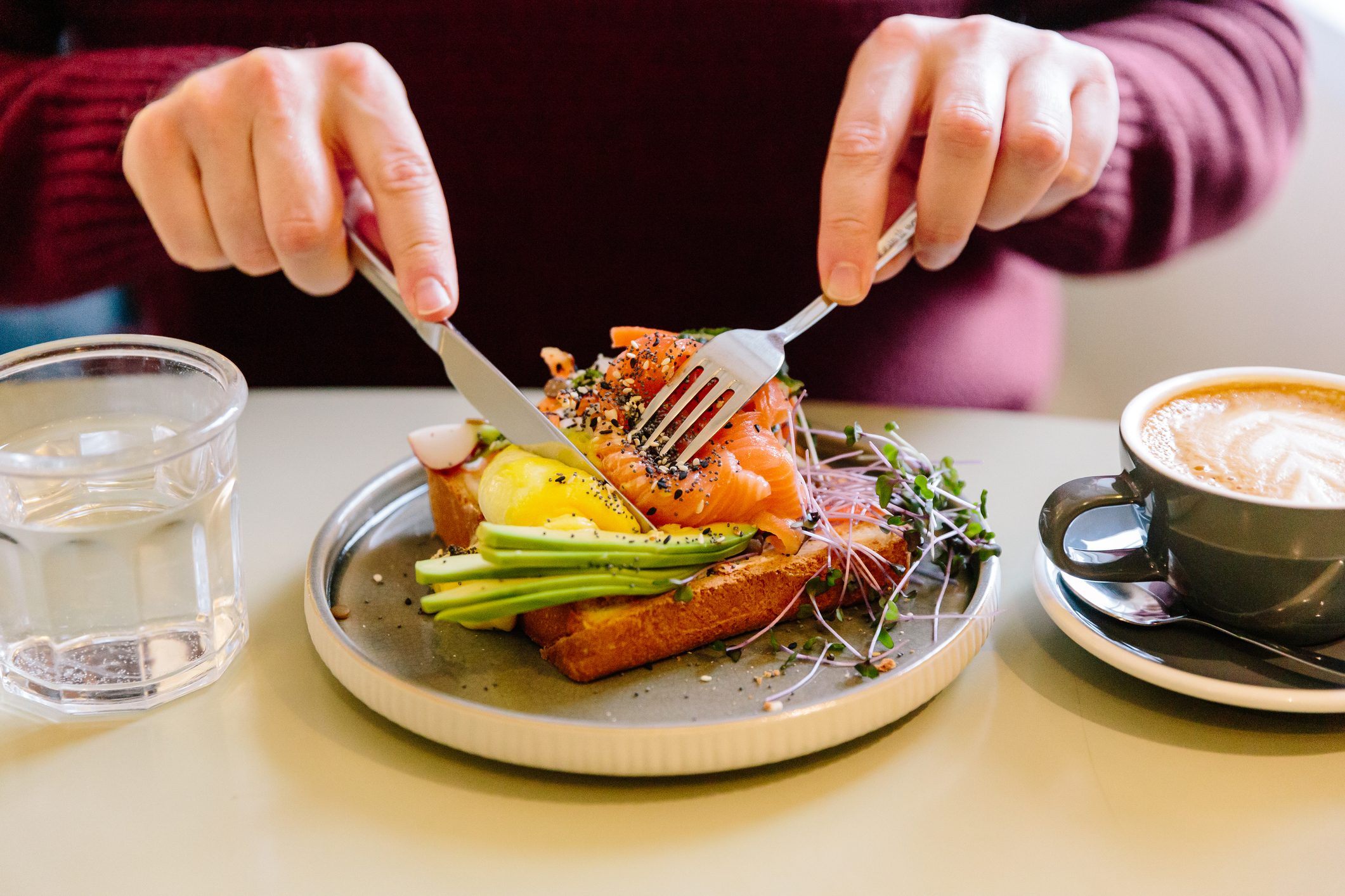 Man eating avocado toast with salmon, close-up