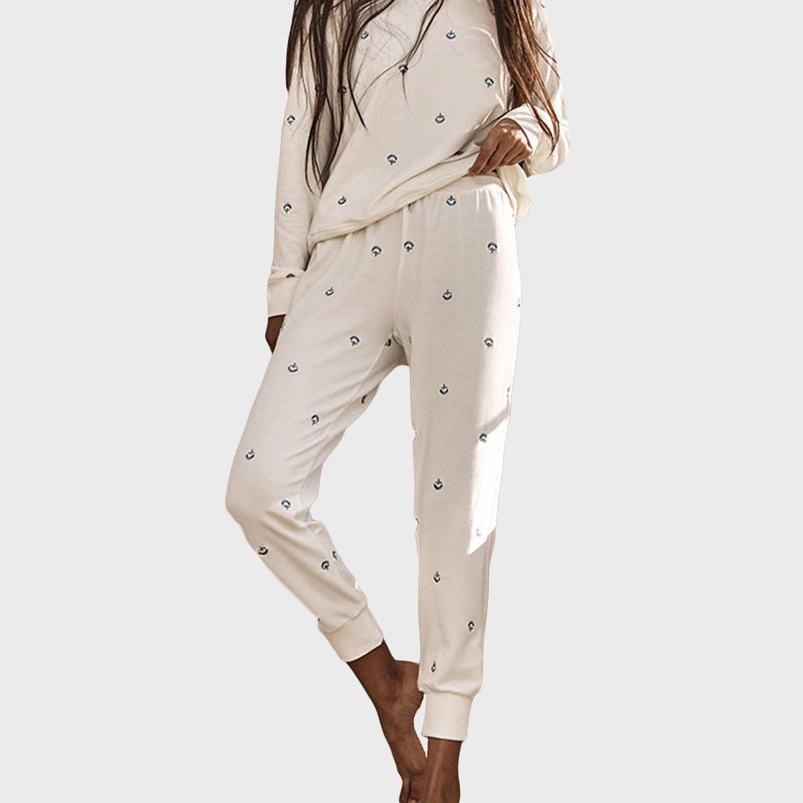 Person wearing cream pajamas with small patterns, standing casually, against a plain background.