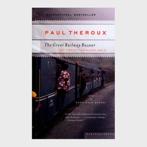 Train passengers lean out windows; a man stands nearby wearing a patterned shirt. Text: 