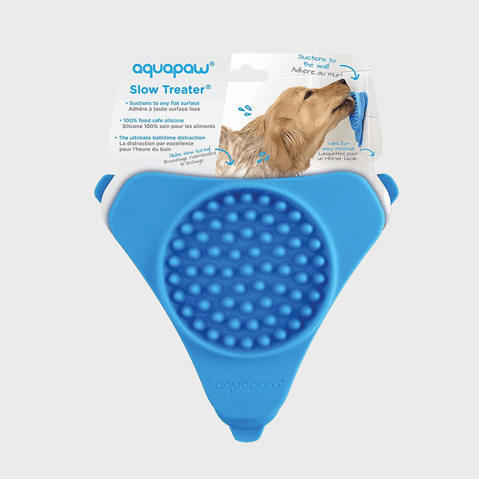 A blue silicone pet treat mat suctions to walls, shown in packaging with a dog licking the surface in a bathroom setting.