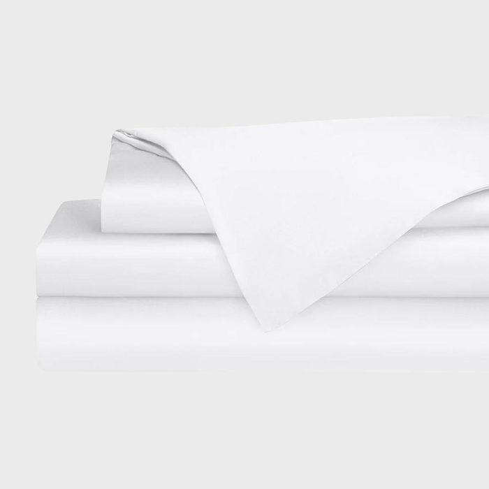 White sheets neatly folded, stacked in a minimalist manner against a plain, light gray background.
