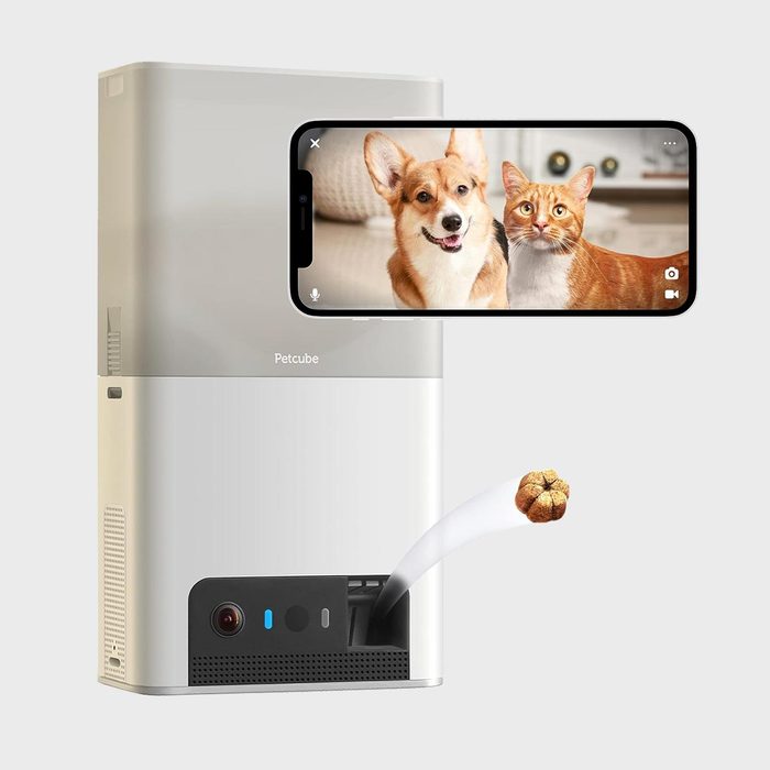 Device launches pet treat; screen displays dog and cat. The context is a clean, neutral background. Text: 