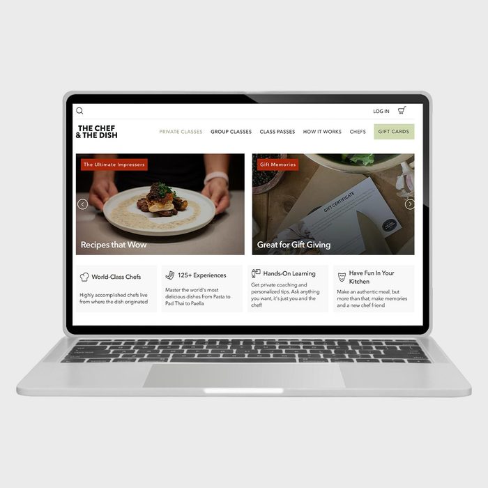 A laptop screen displays a cooking website featuring recipes, gift ideas, and learning experiences in a structured layout under various categories and menu options.