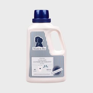 Laundry detergent bottle stands upright, featuring a striped label with 