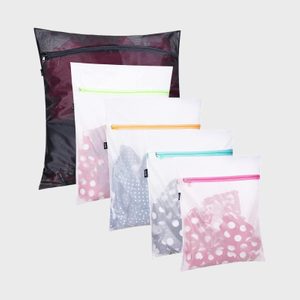 Five translucent bags display clothes, featuring various colored zippers, arranged against a plain background. Each bag contains polka-dot patterned fabric.