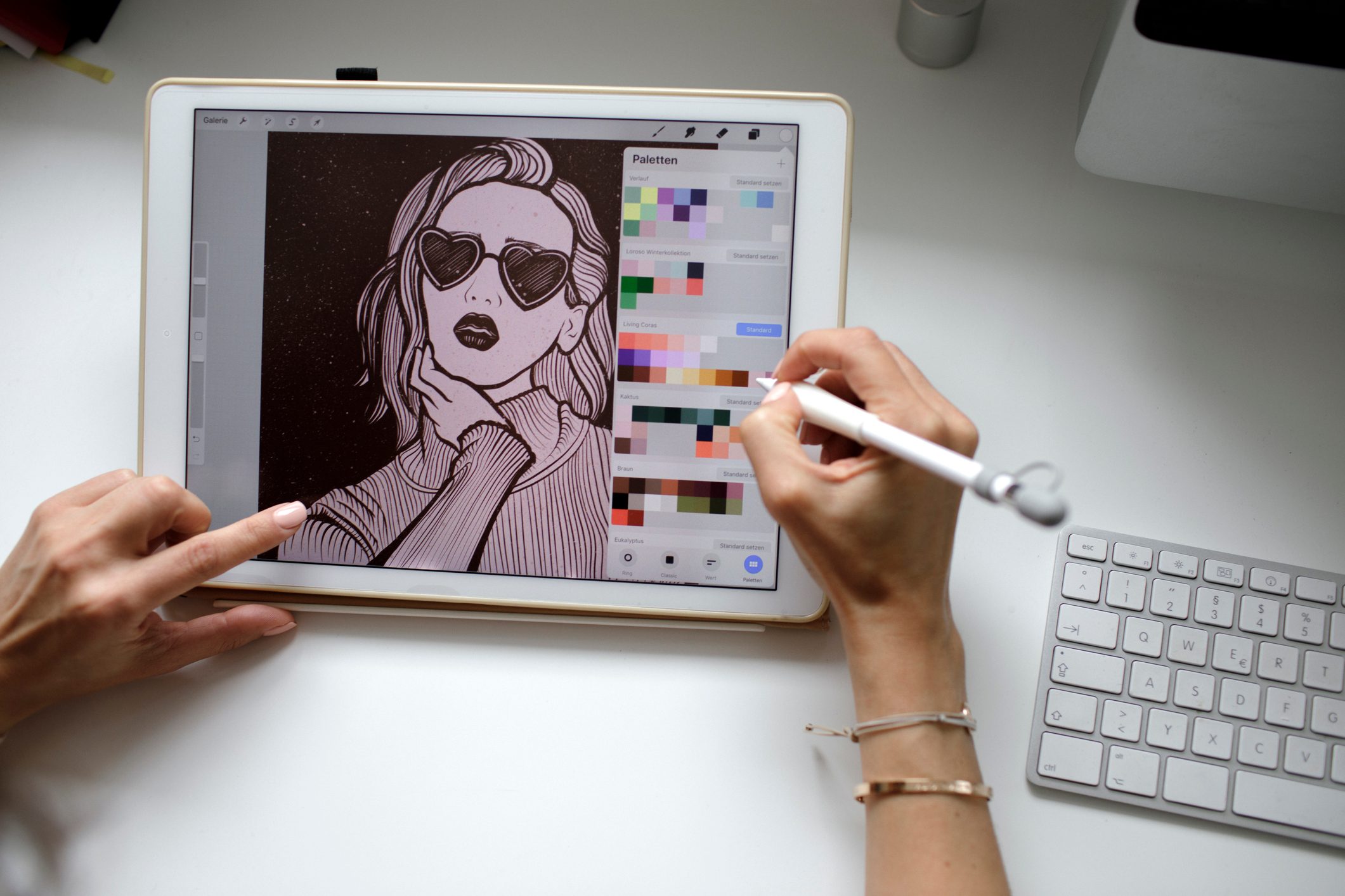 Tablet screen displays digital illustration, edited with stylus; keyboard on white desk surface, creating a digital art workspace.