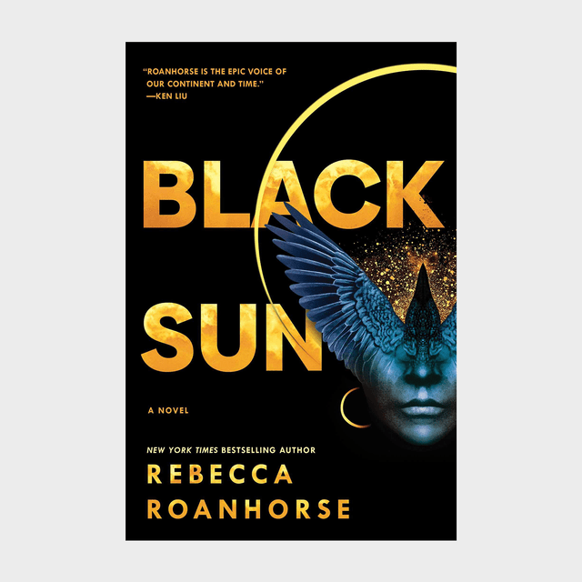 Book cover shows a blue bird overlaid on a face with shimmering gold text: &acirc;&euro;&oelig;Black Sun&acirc;&euro; by Rebecca Roanhorse, highlighted by a vivid eclipse.
