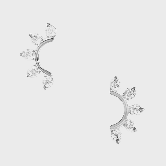 Sparkling curved earrings feature multiple teardrop-shaped stones, arranged in a radiating pattern, set against a plain, white background.