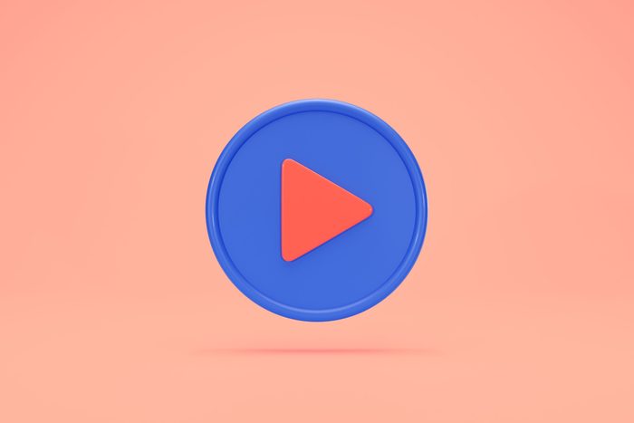 video play button floating on peach background