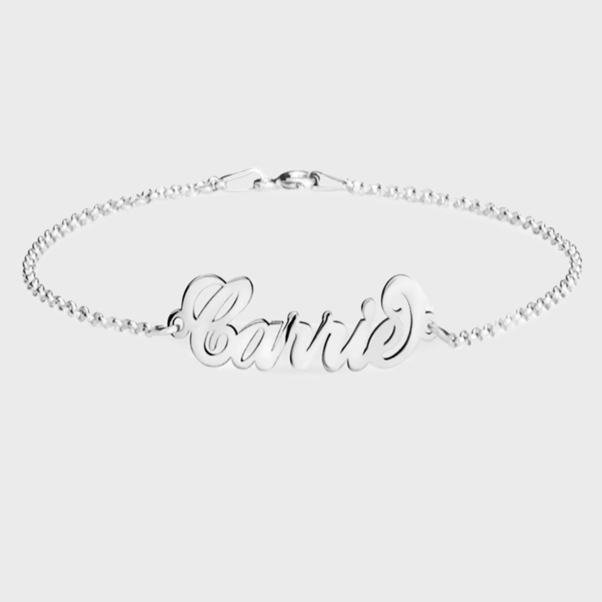 Silver bracelet displays text "Carrie," elegantly styled, against a plain white background.