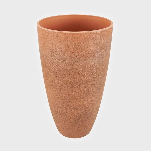 A tall, cylindrical terracotta pot stands upright against a plain white background.