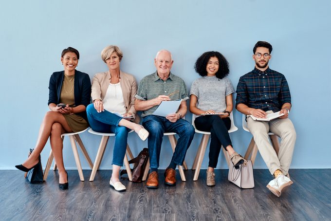 Group of candidates waiting for their interview against a blue background