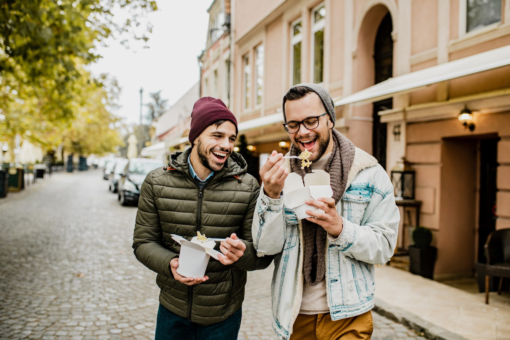 Two friends eating fast food outdoors