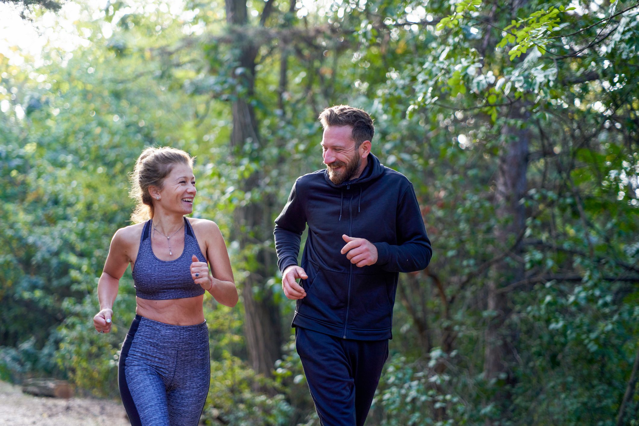 happy couple running for health in the park
