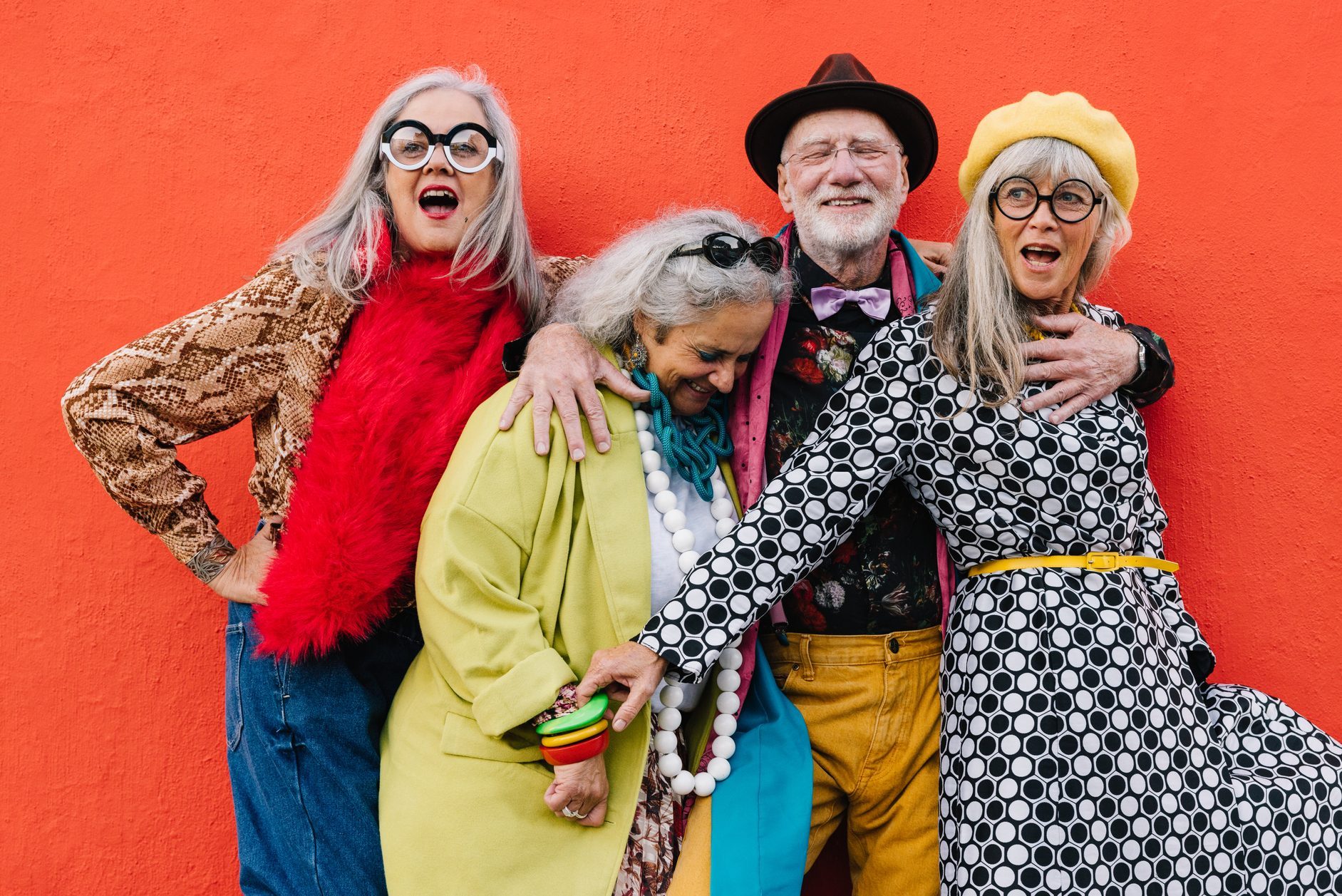 Vibrant senior citizens having fun against a red background