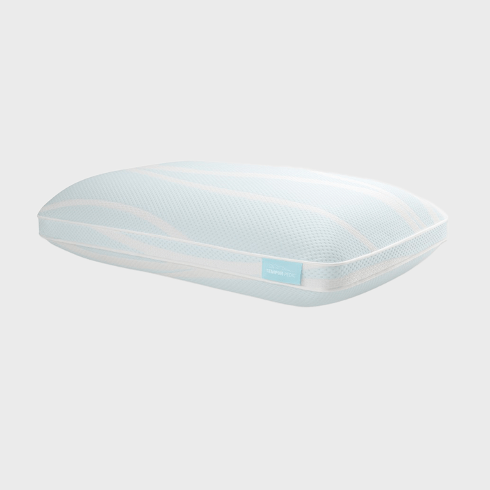 A light blue, contouring pillow rests against a plain, white background. Text on the pillow reads: 