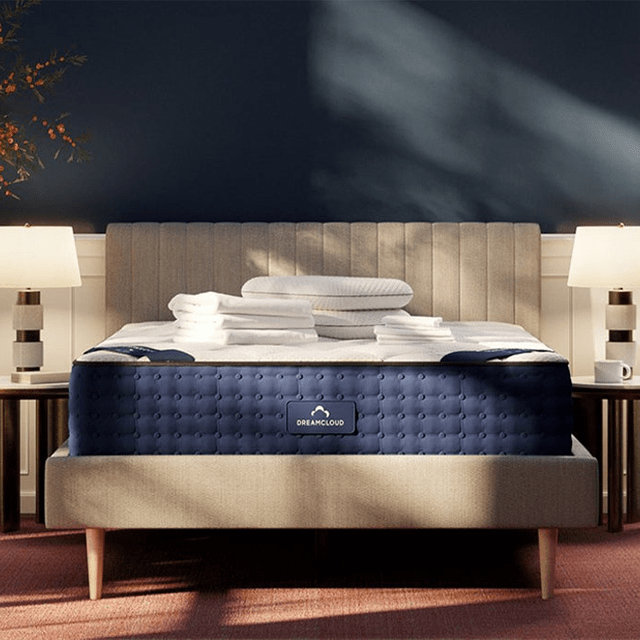 Bed displays neatly folded linens, positioned symmetrically in a cozy, softly lit bedroom with matching lamps. 