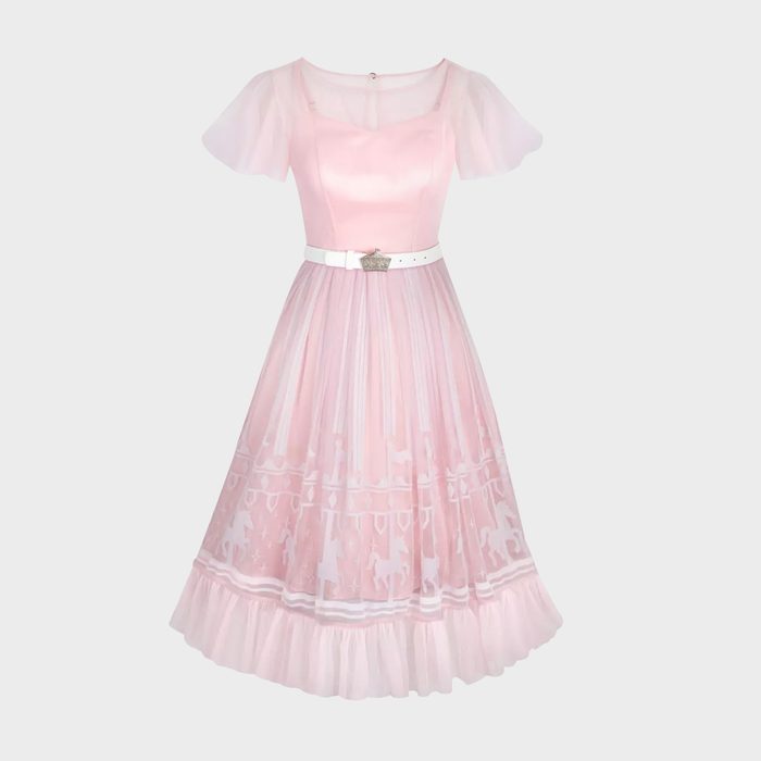 Pink dress features short sheer sleeves, a fitted bodice, and flared skirt adorned with carousel horse patterns; white belt accentuates waist.