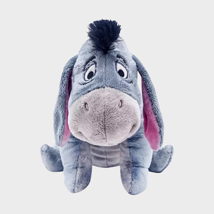 Plush donkey sits on a blank surface, displaying a friendly appearance with soft gray fur and floppy ears.