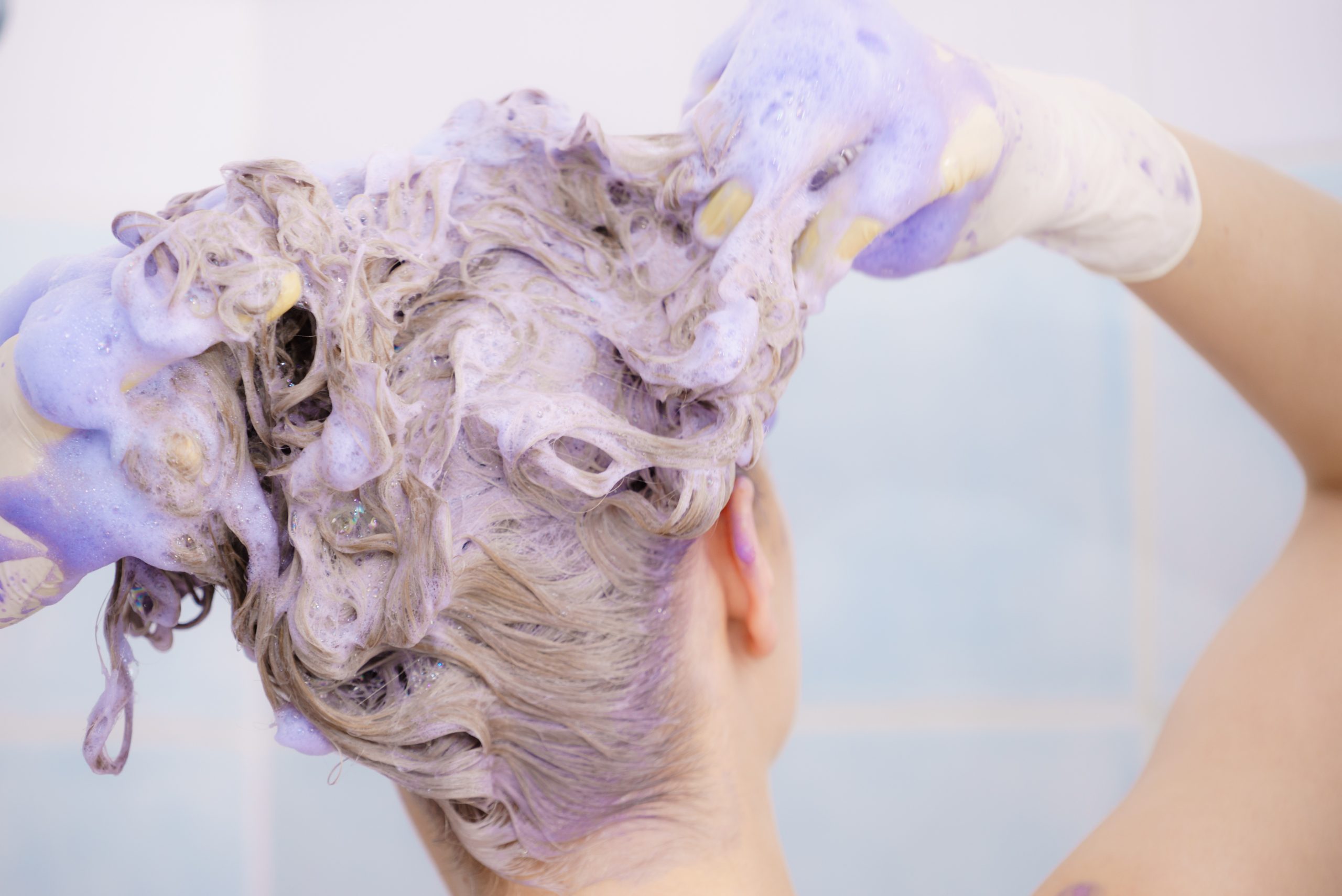 Woman applying toner shampoo on her hair