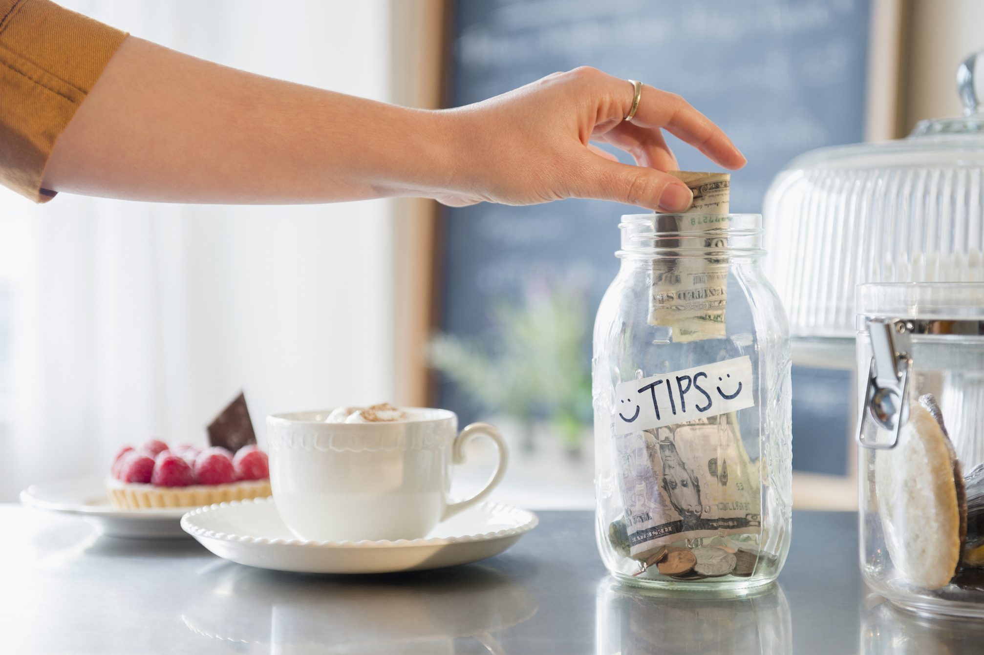Caucasian woman putting money in tip jar
