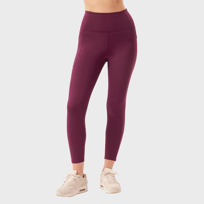 Purple leggings worn by a person standing, paired with white sneakers, against a plain white background.