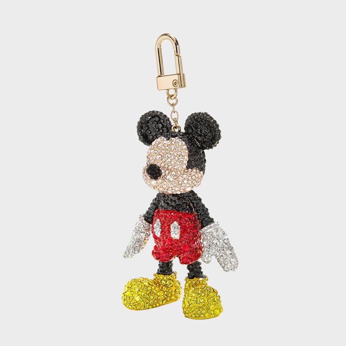 Crystal-encrusted character keychain hangs; featuring black ears, red shorts, yellow shoes; against a plain background.