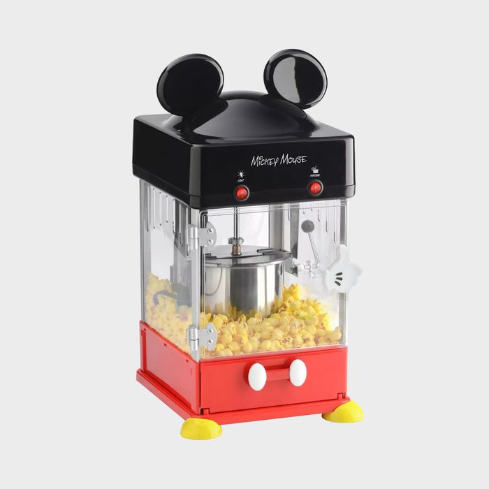 Popcorn maker pops fluffy kernels, featuring a cartoon-inspired design with black ears and red buttons, placed on a neutral background.