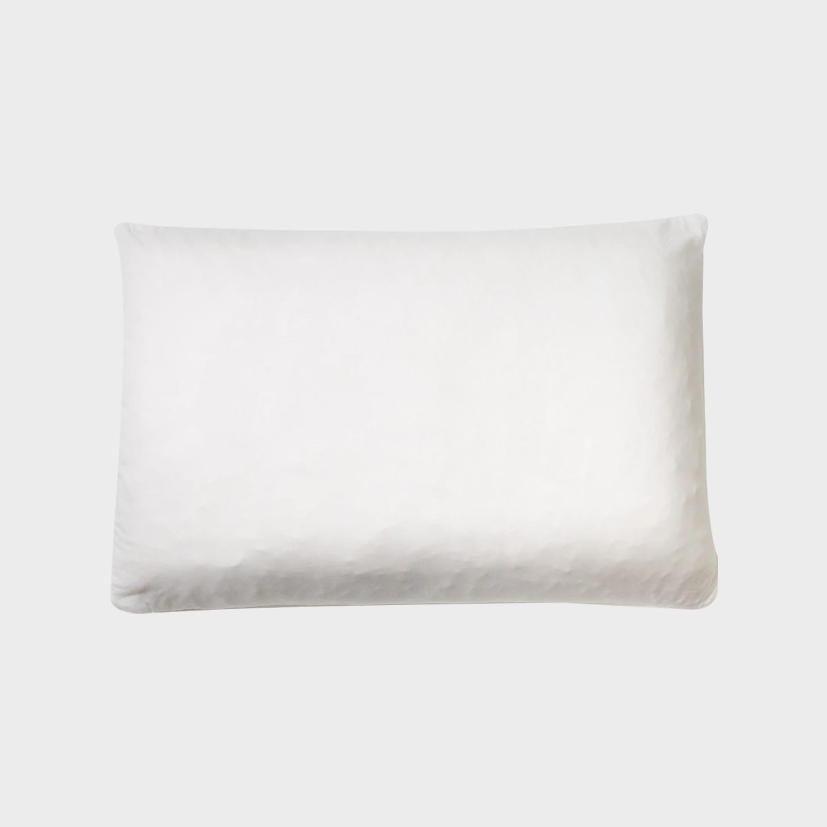 White pillow resting against a plain, light gray background.