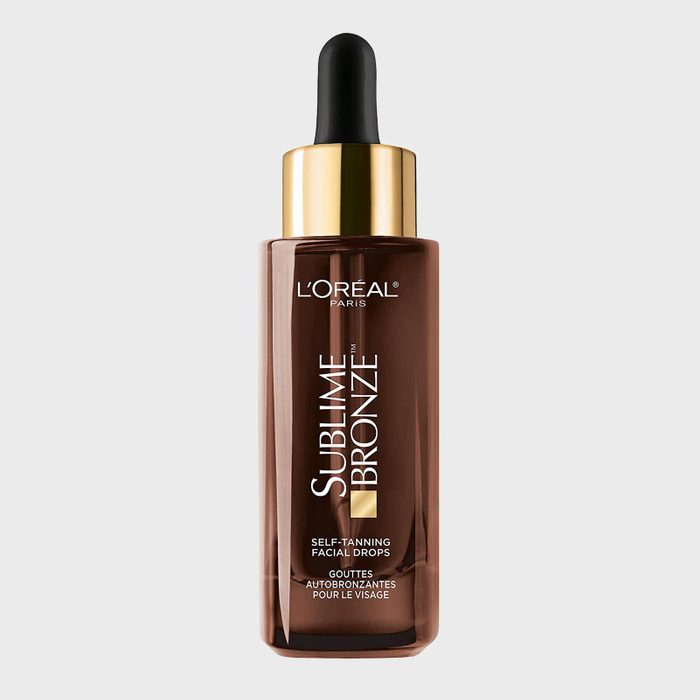Dark brown bottle with a black dropper, labeled L'Oreal Paris Sublime Bronze Self-Tanning Facial Drops against a plain gray background.