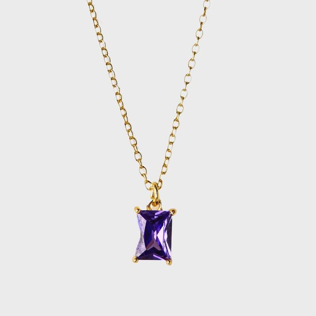 A gold chain necklace holds a rectangular purple gemstone pendant against a plain white background.