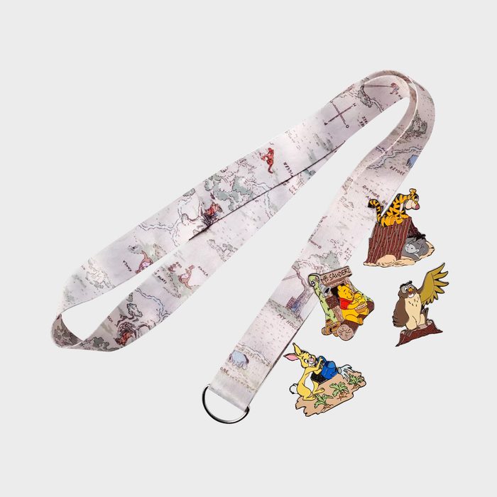Lanyard featuring map design lies flat, surrounded by colorful cartoon character pins, including a tiger, bear, donkey, and owl, against a plain background.