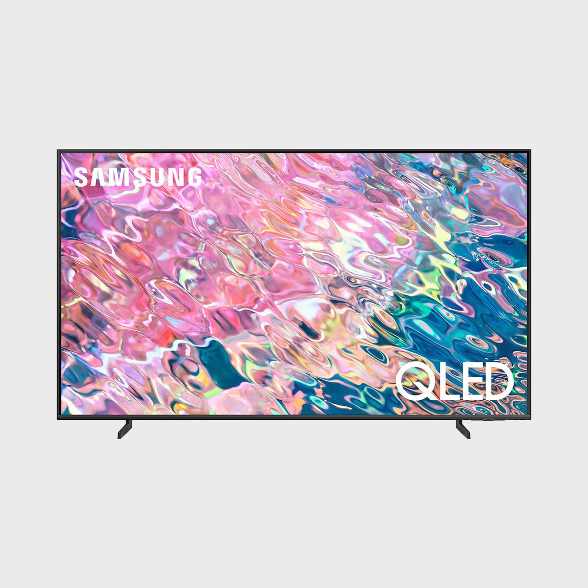 TV displays colorful abstract art; "SAMSUNG" and "QLED" text appear on the screen. The TV has a minimalistic design against a plain background.