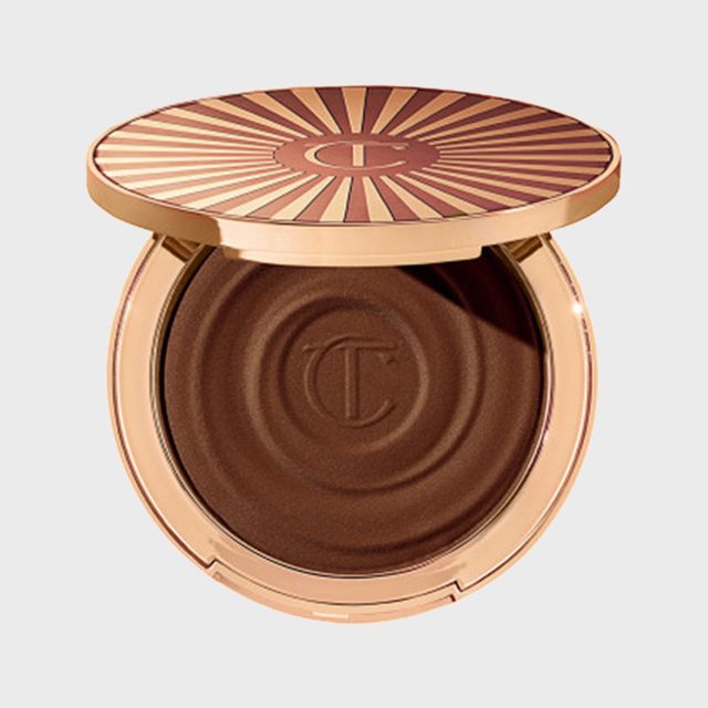 Compact container displaying opened bronzer in circular shape with embossed 