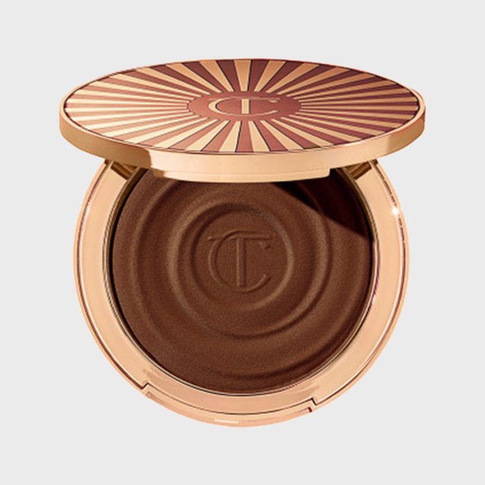 Compact container displaying opened bronzer in circular shape with embossed 