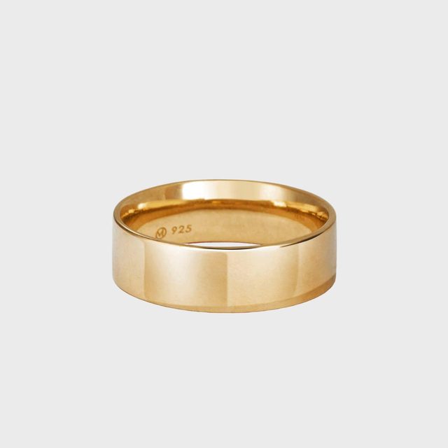 A gold band rests on a plain gray background, with 