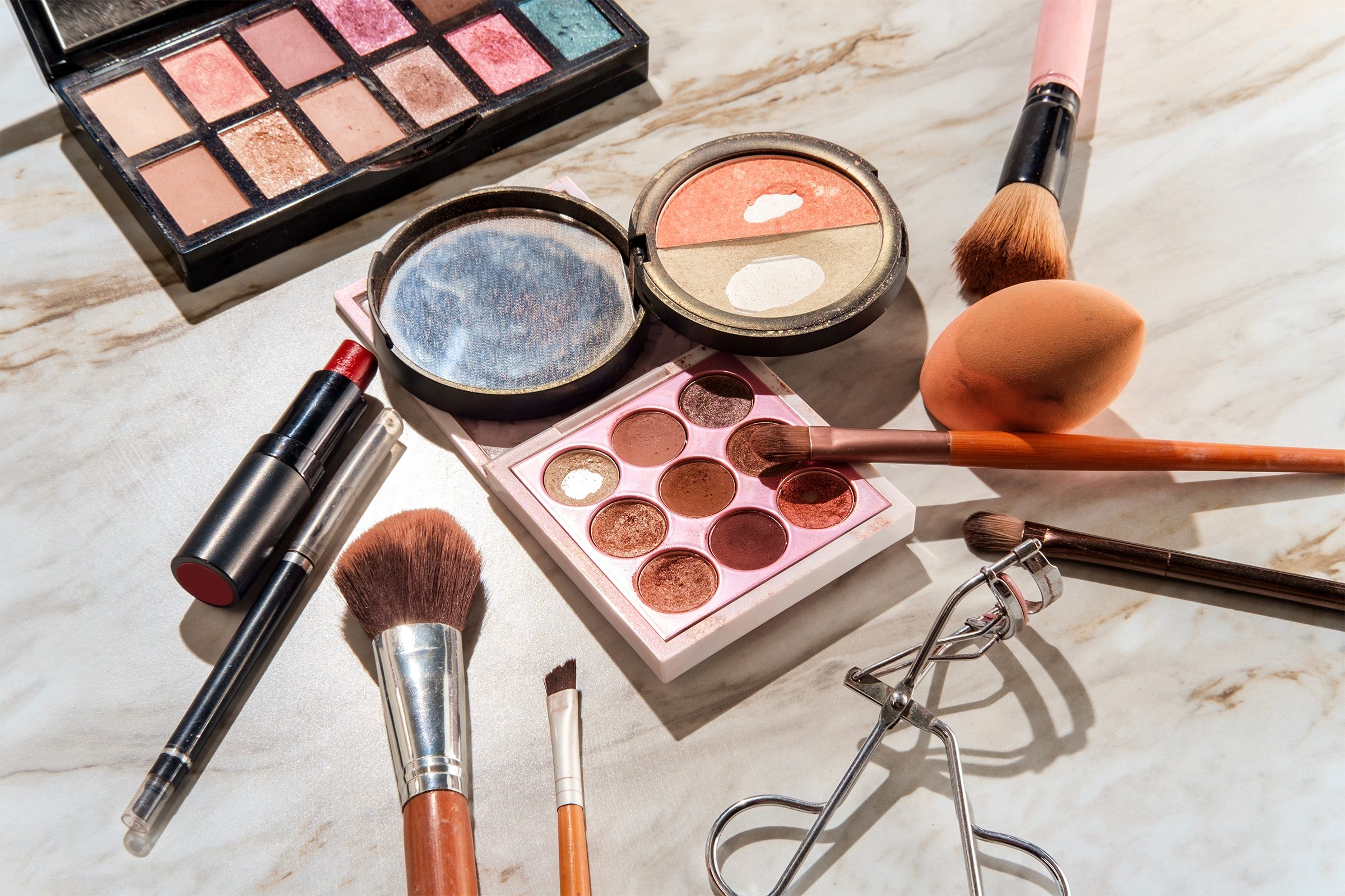 Used beauty cosmetics products on a marble table