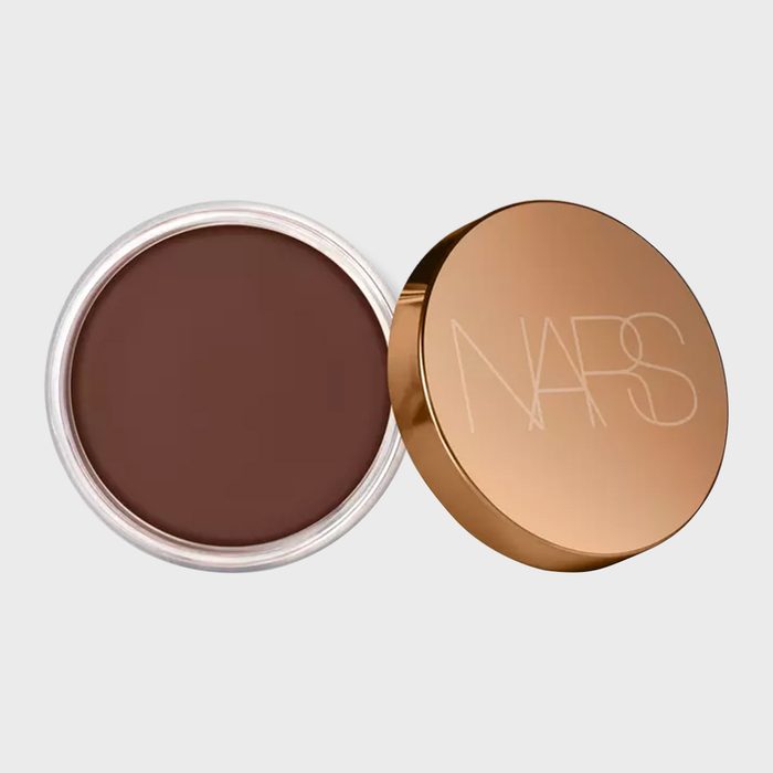Brown makeup in open round container; gold lid with 