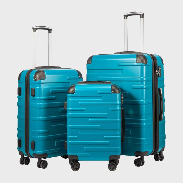Three teal suitcases stand upright, displaying retractable handles and wheels, set against a plain background.