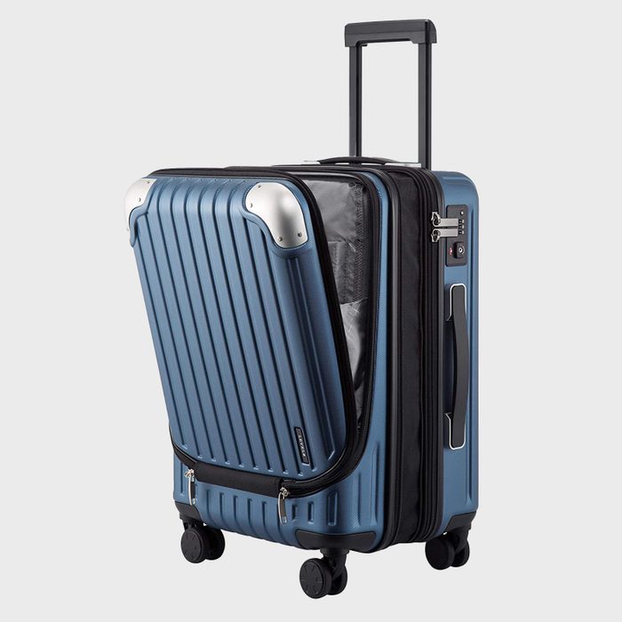 Suitcase partially open, exposing interior compartments, stands on four wheels; silver corner protectors accentuate its ribbed blue exterior.