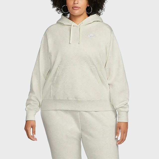 Person wearing a light gray hoodie and matching sweatpants, standing against a plain gray background. Nike logo visible on the hoodie.