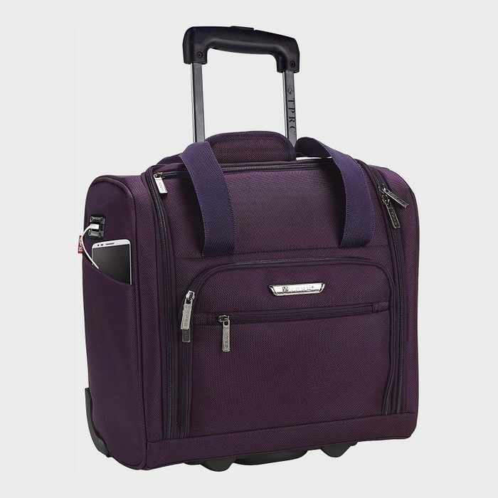 Purple rolling suitcase stands upright, displaying handles, wheels, and a smartphone in its side pocket against a plain, light background.