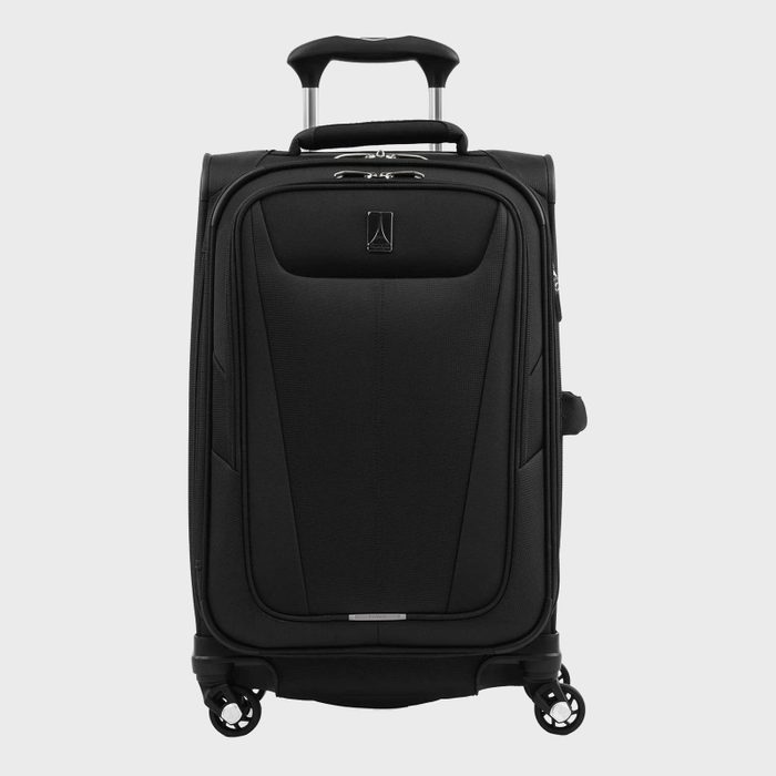 A black suitcase stands upright on four spinner wheels, featuring an extendable handle, against a plain, light gray background.