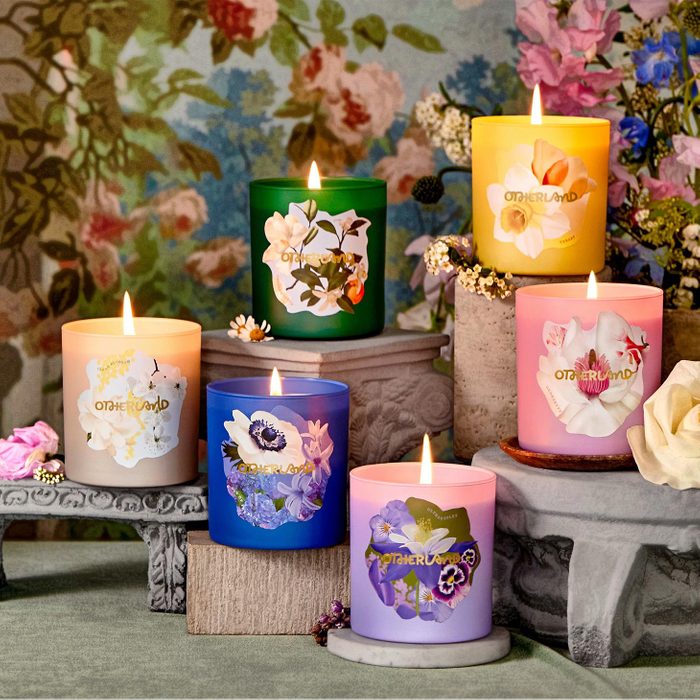 Candles burn softly on decorative stands, surrounded by colorful floral wallpaper and small flowers, each labeled 
