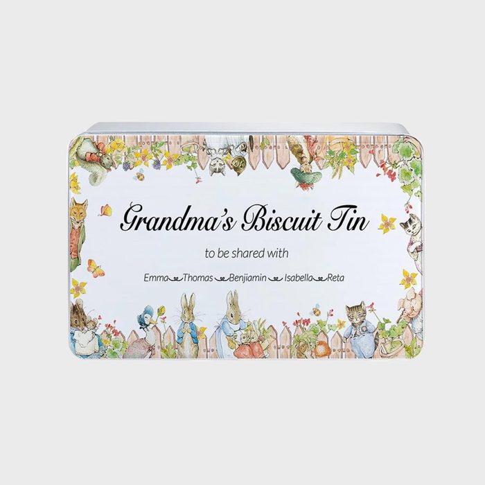 Tin lid features whimsical animals, flowers, and a fence surrounding text: 