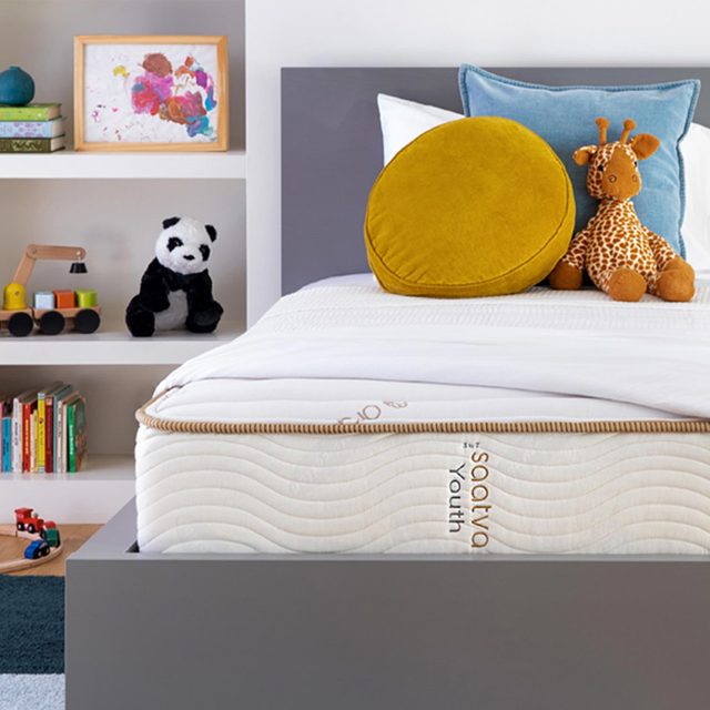 Bed holds round pillow and giraffe toy; shelves display panda plush, wooden toy, books, and colorful artwork; text reads 