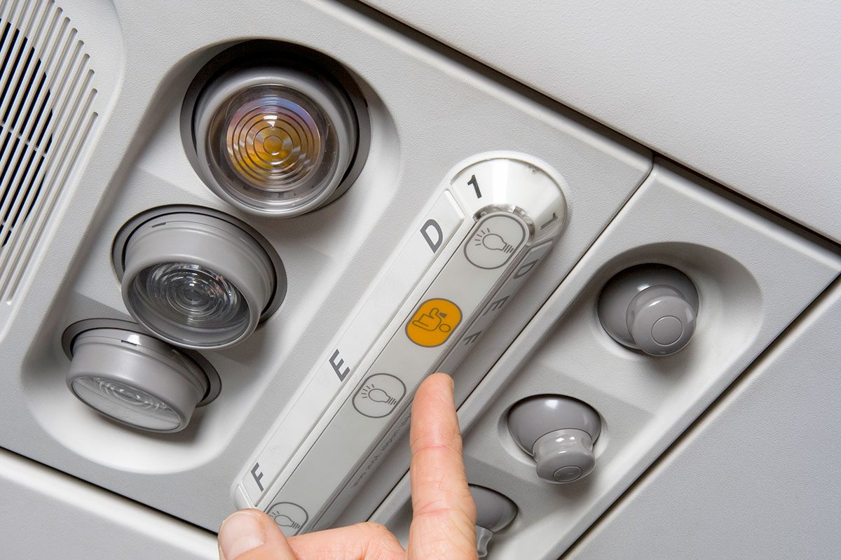 A Finger Pressing The Call Button On An Airplane