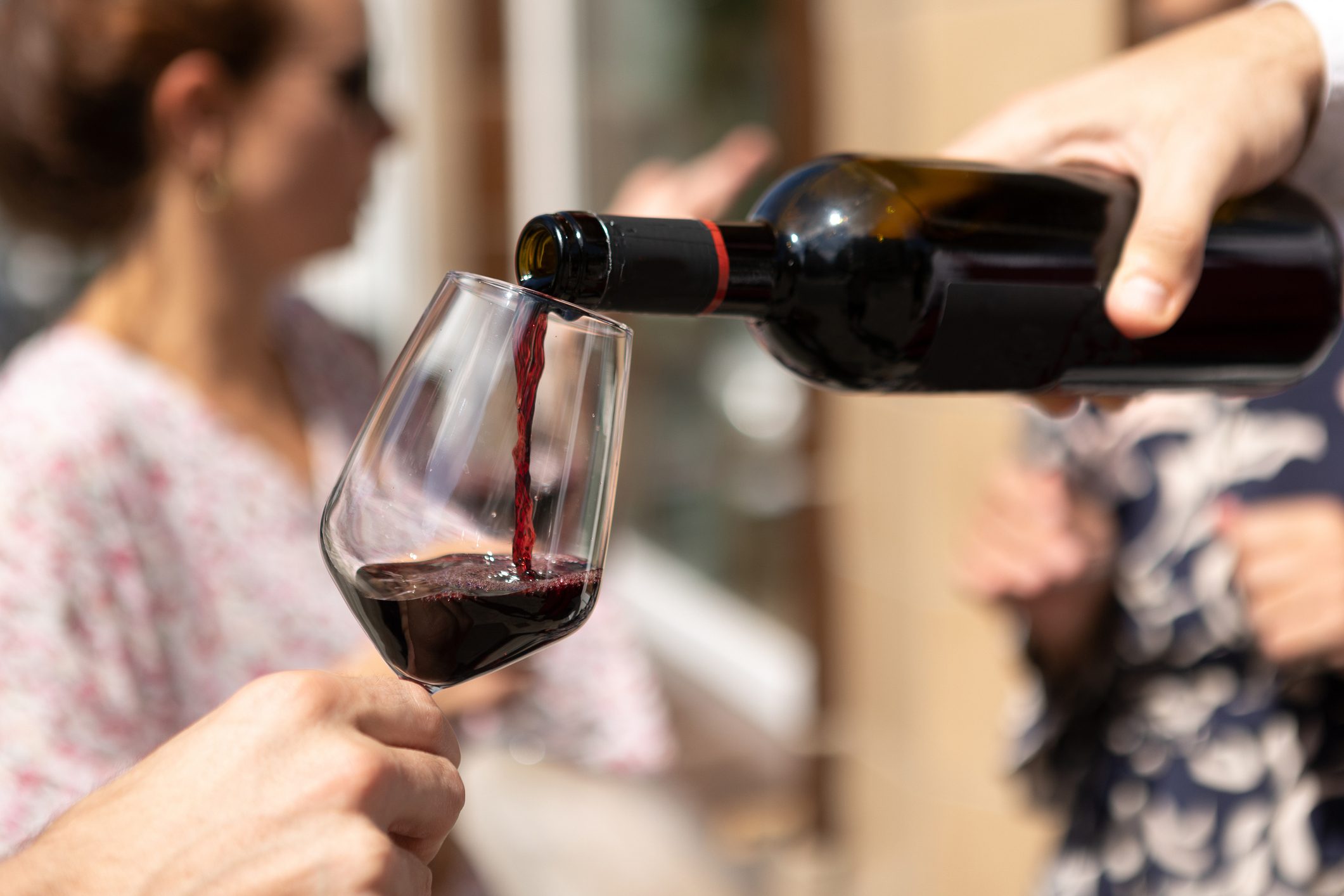 Hand Of Waiter Pouring Alcohol To Customer Holding Glass - Bar Or Restaurant Aperitif Happy Hour