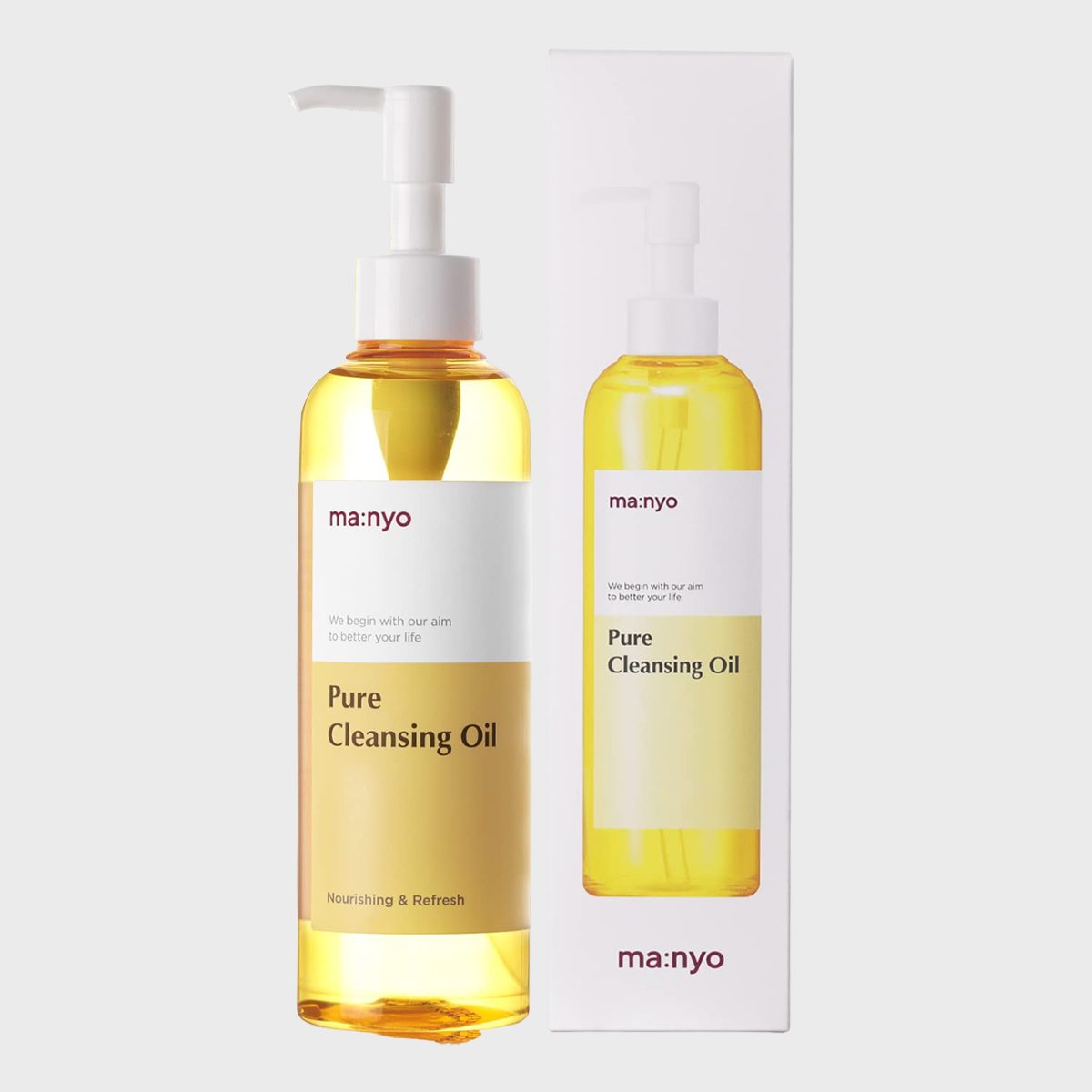 Bottle with pump dispenses cleansing oil, placed beside matching box, both labeled "ma:nyo Pure Cleansing Oil" in a minimalistic design.